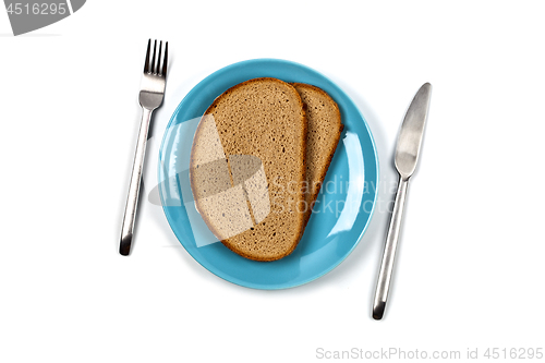 Image of Fresh baked bread slices on blue plate, fork and knife on white 