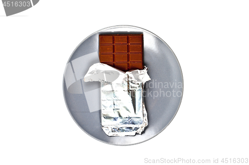 Image of Chocolate bar with foil on grey ceramic plate isolated on white 