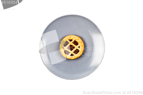 Image of Chocolate tart on grey ceramic plate on white background. 