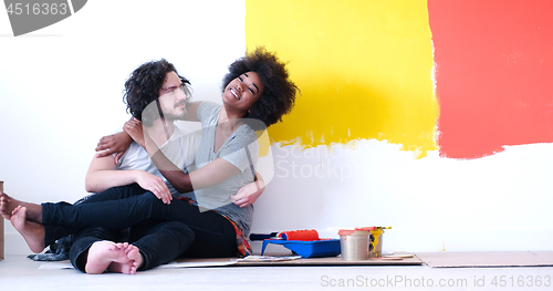 Image of young multiethnic couple relaxing after painting