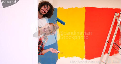 Image of portrait of a couple painting interior wall