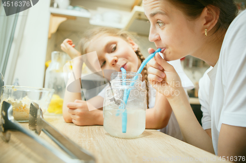 Image of The happy smiling caucasian family in the kitchen preparing breakfast