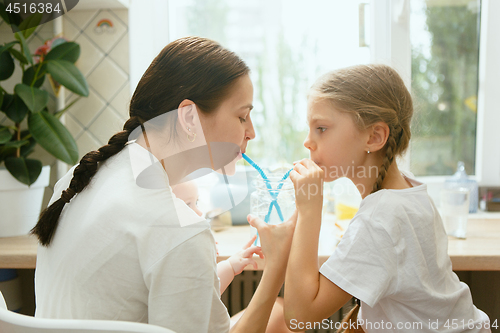 Image of The happy smiling caucasian family in the kitchen preparing breakfast