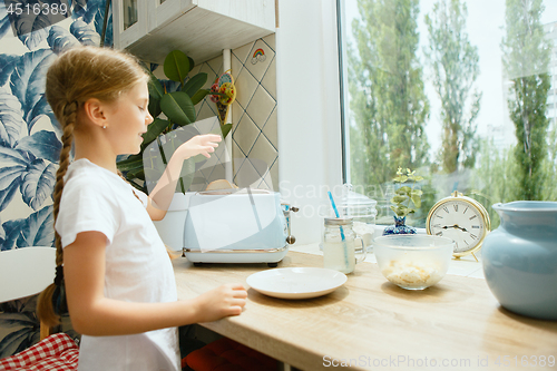 Image of Beautiful girl in her kitchen in the morning preparing breakfast