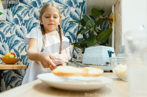 Image of Beautiful girl in her kitchen in the morning preparing breakfast