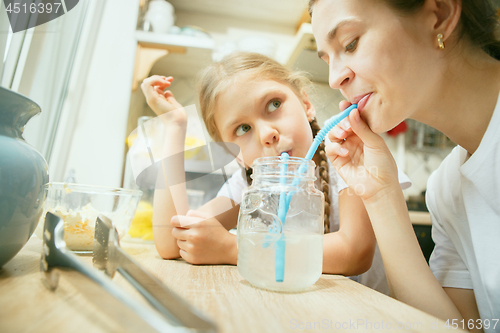 Image of The happy smiling caucasian family in the kitchen preparing breakfast