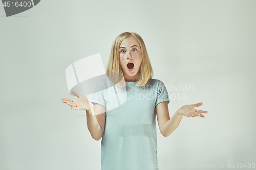 Image of Beautiful woman looking suprised isolated on gray