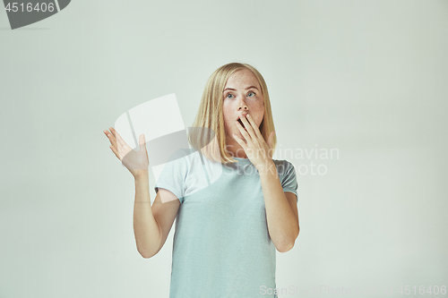 Image of Beautiful woman looking suprised isolated on gray