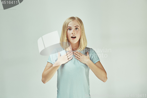 Image of Beautiful woman looking suprised isolated on gray