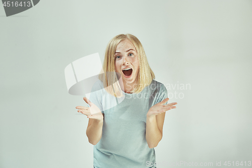 Image of Beautiful woman looking suprised isolated on gray