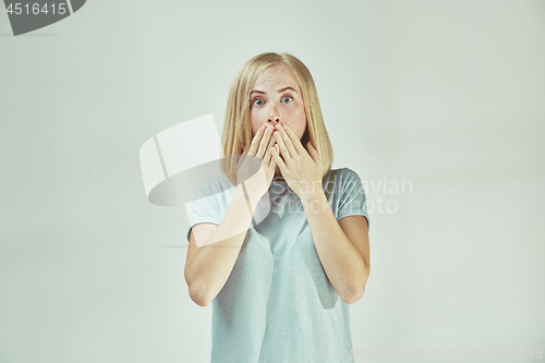 Image of Beautiful woman looking suprised isolated on gray