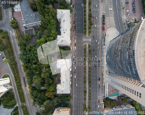 Image of Top view of a modern business center building with a high-speed highway near it. Photo from the drone.