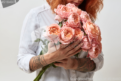 Image of the girl is holding a bouquet of pink roses