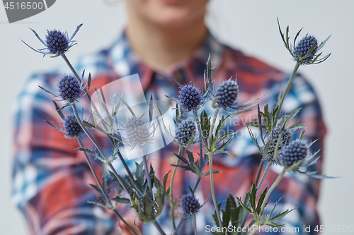 Image of Young girl holding a blue flower