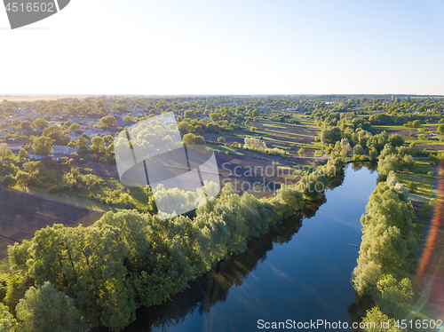 Image of aerial view of a blue lake, green forest and blue sky