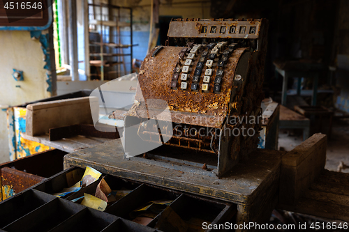 Image of Old and rusty cash mashine on the desk