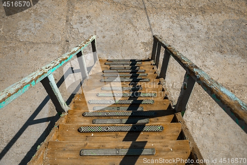 Image of Long wooden staircase going down