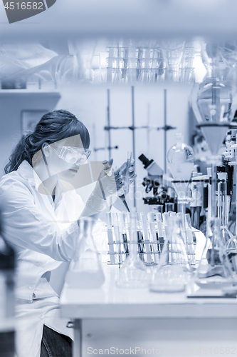 Image of Young scientist pipetting in life science laboratory.