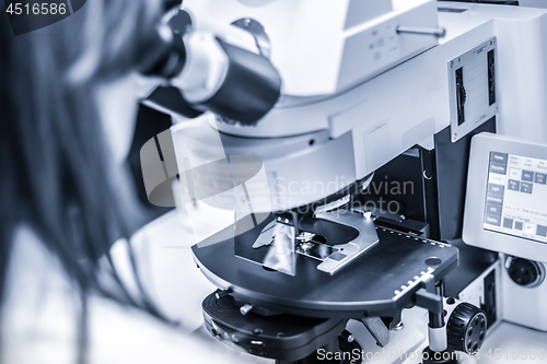 Image of Helth care professional microscoping on hi-tec fluorescent microscope.