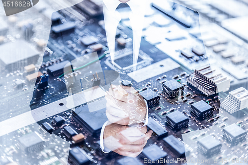 Image of Businessman wearing fashionable classic navy blue suit against pc motherboard chip photo layer