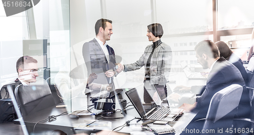 Image of Business people shaking hands in moder corporate office.