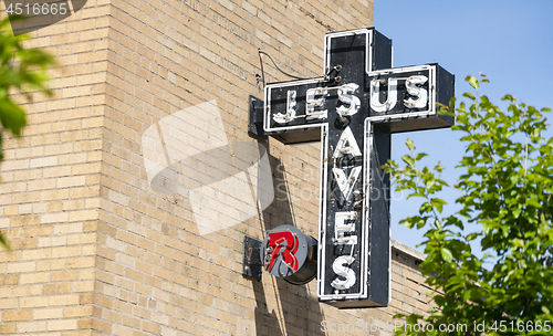 Image of Neon Jesus Saves Sign Brick Wall Church Exterior
