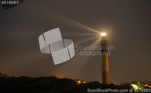 Image of Oak Island Lighthouse Beams into the Seafoam at Fort Caswell