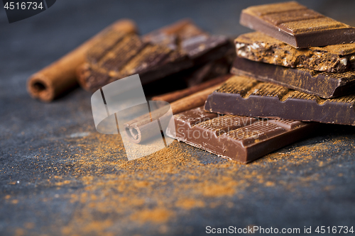 Image of Chocolate stacked on black background. Chocolate bar pieces heap