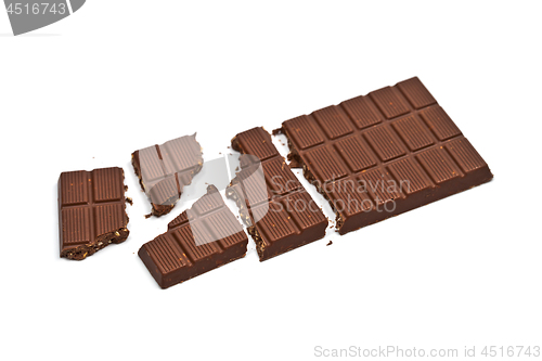 Image of Broken milk chocolate bar with hazelnuts isolated on white.