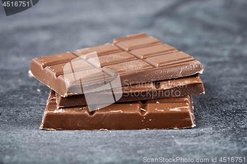 Image of Milk chocolate bar pieces closeup. Sweet food photo concept.