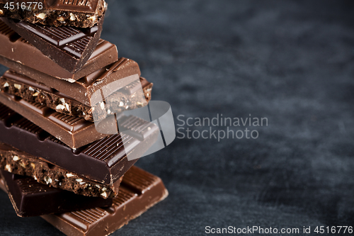 Image of Chocolate bar pieces closeup. Sweet food photo concept with copy