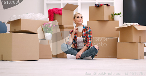 Image of woman with many cardboard boxes sitting on floor