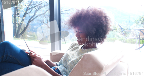 Image of african american woman at home using digital tablet