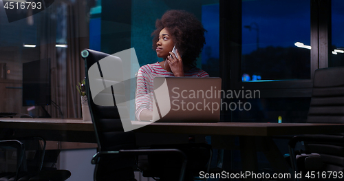 Image of black businesswoman using a laptop in night startup office