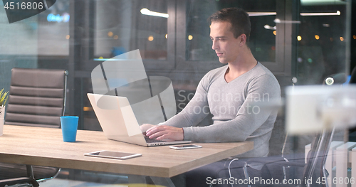 Image of man working on laptop in dark office