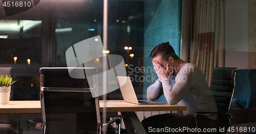 Image of man working on laptop in dark office