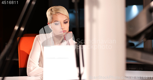 Image of woman working on laptop in night office