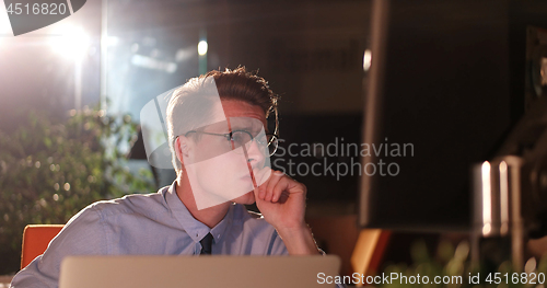 Image of man working on computer in dark office