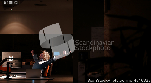 Image of man working on computer in dark office