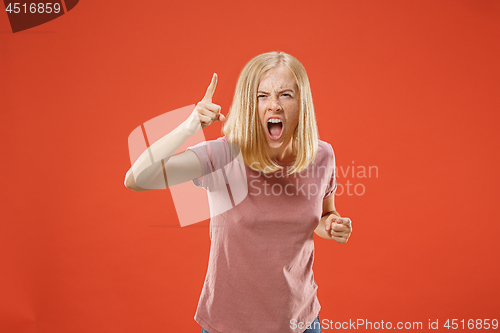 Image of Beautiful female half-length portrait isolated on red studio backgroud. The young emotional surprised woman