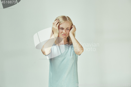 Image of Woman having headache. Isolated over pastel background.