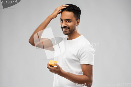 Image of indian man applying hair wax or styling gel