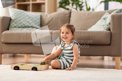 Image of happy baby girl playing with toy blocks at home