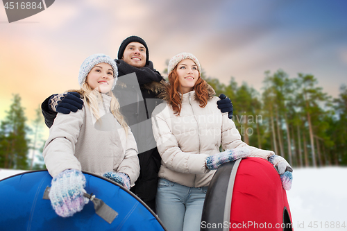 Image of happy friends with snow tubes outdoors in winter