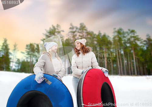 Image of happy teenage girls with snow tubes in winter
