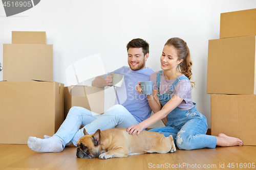 Image of happy couple with boxes and dog moving to new home