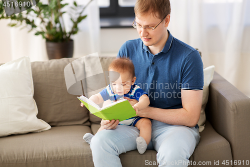 Image of happy father and little baby son with book at home