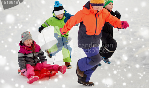 Image of happy kids with sled having fun outdoors in winter