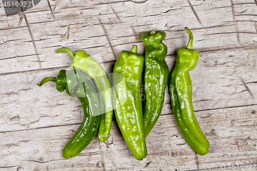 Image of Fresh green raw peppers on rustic wooden table background. 