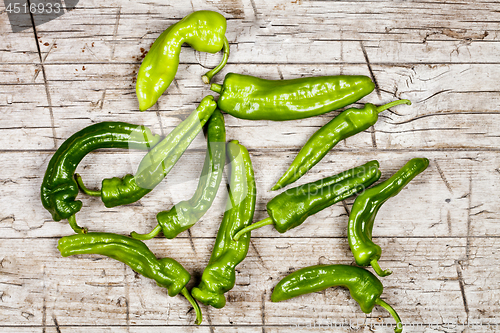 Image of Fresh green raw peppers group on rustic wooden table background.